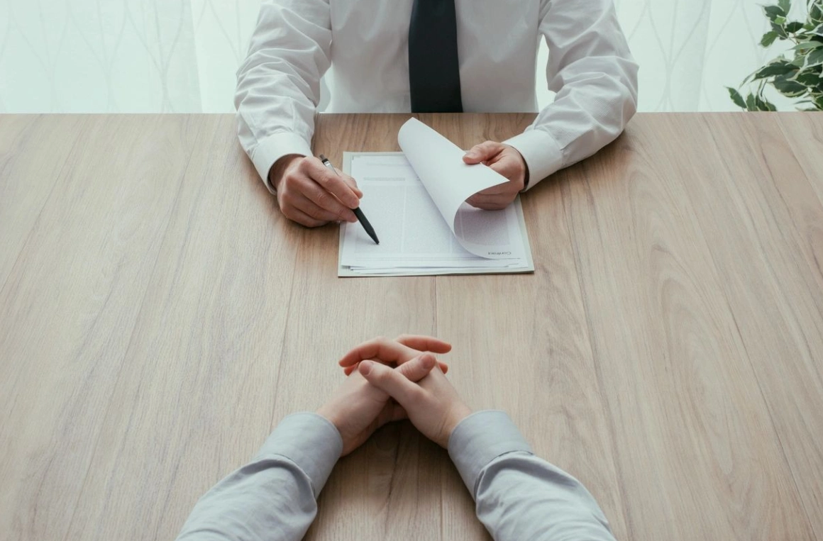 A man is interviewing someone at the table.